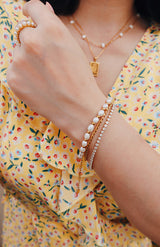 Woman in dress layering bracelets for her summer outfit