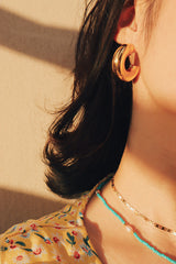Woman wearing enduring and stylish gold thick hoops, perfect for any occasion.