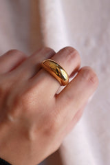 Woman wearing a tarnish free gold ring on the middle finger