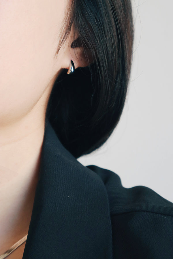 女人配戴抗敏感銀色金屬光面耳環