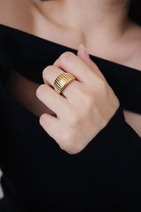 Woman in nightout dress wearing trendy textured gold ring