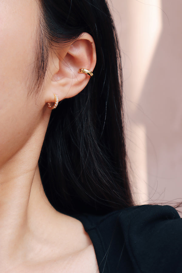 Girl wearing zoe shimmering gold huggie with a stunning ear clip.