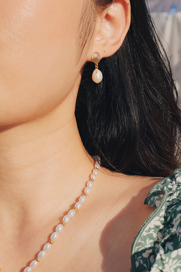 Woman wearing hypoallergenic 18k gold-plated pearl drop earrings