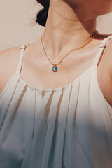 Woman wearing blue cat eye stone necklace for summer vacation