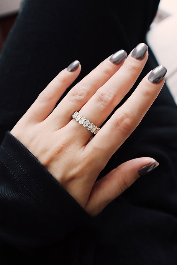 模特兒手部佩戴銀色鋯石排戒，搭配灰色指甲與黑色上衣，呈現俐落極簡風格。