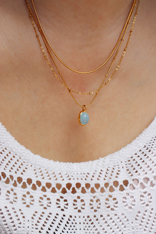 Stainless steel gold layered necklace styled with a white lace top, offering a soft yet modern everyday aesthetic.