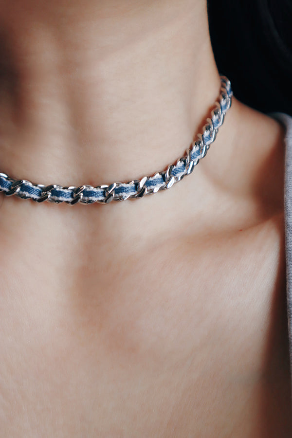 丹寧銀鏈項鍊貼合鎖骨，冷調金屬與布料融合展現時髦層次。