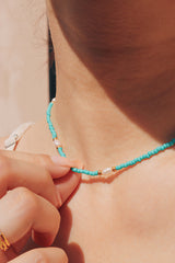 Blue bead and pearl choker enhancing a trendy summer outfit