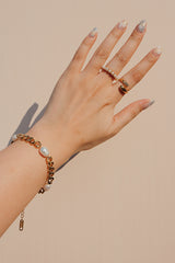 Woman styling with gold plated cuban bracelet and dainty ring