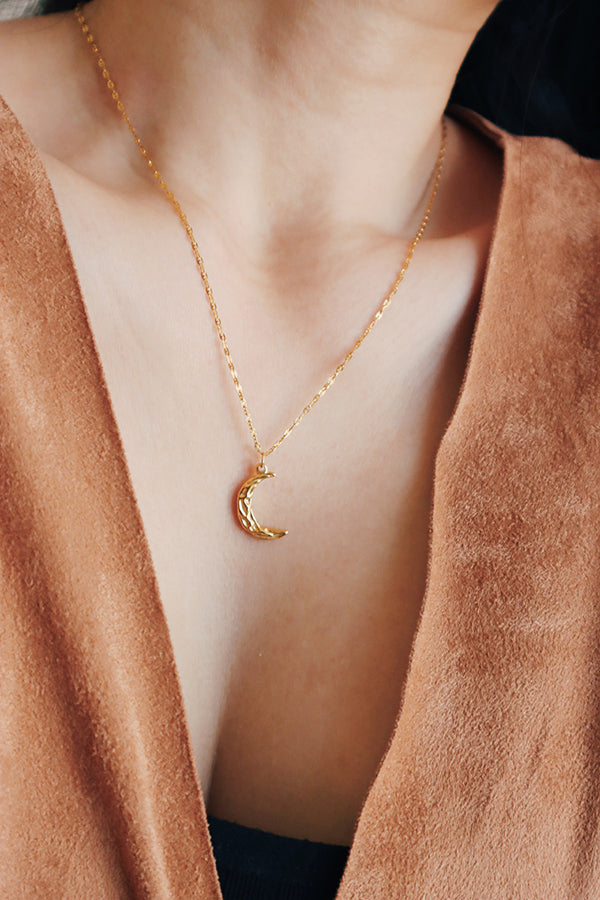 女性配戴著適合冬天毛衣的金色月亮項鍊