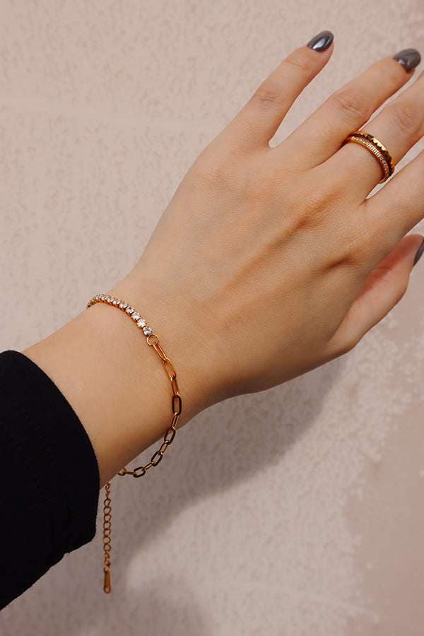 Zircon chain bracelet styled with minimalist rings, creating a refined layered jewelry look.