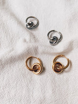 Two sets of gold and silver each placed on crumpled white cloth