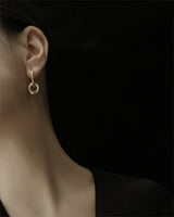 Model wearing gold hoop earrings showing a beautiful neck line shot in studio