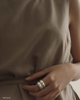 Model wearing silver stacked rings with hands on waist