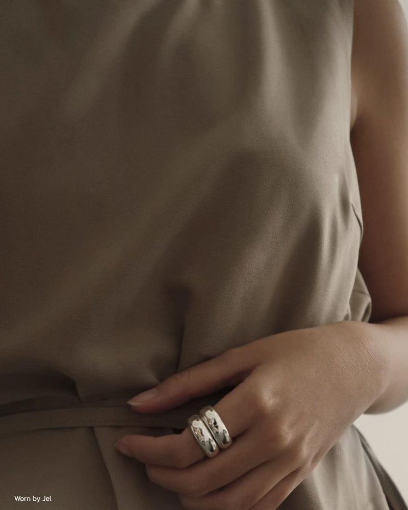 Model wearing silver stacked rings with hands on waist
