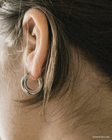 Side profile of a lady wearing a small silver hoop earrings