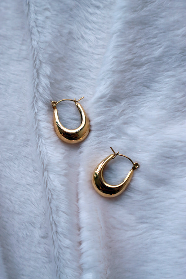 Stainless steel 18k gold plated hoops on the white blanket