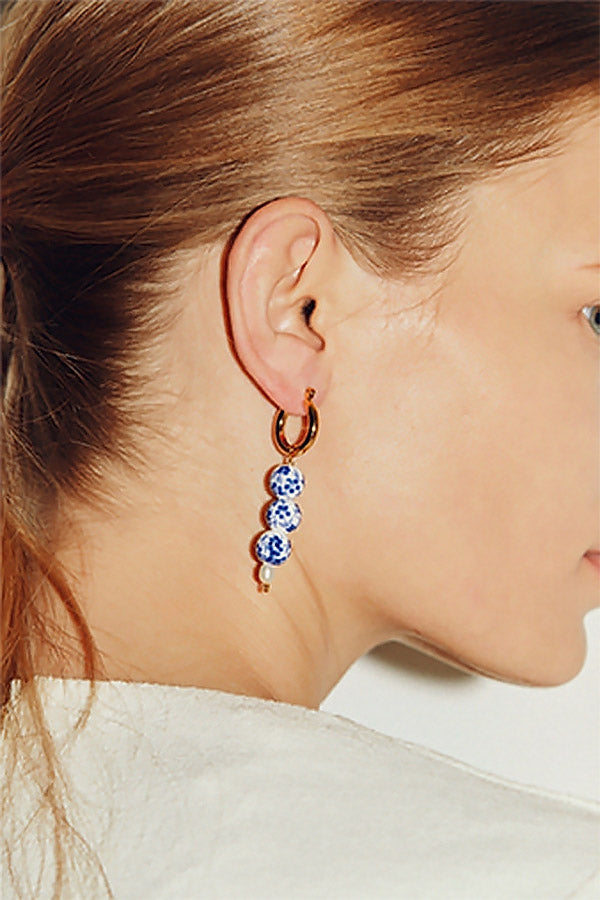 Side profile of gorgeous model wearing oriental beads earrings
