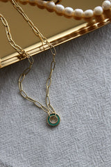 Gold chain malachite necklace on a gold plate