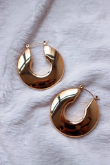 Hypoallergenic material gold hoop earrings on white cloth