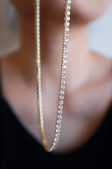 Woman showing the details of rhinestone necklace to camera