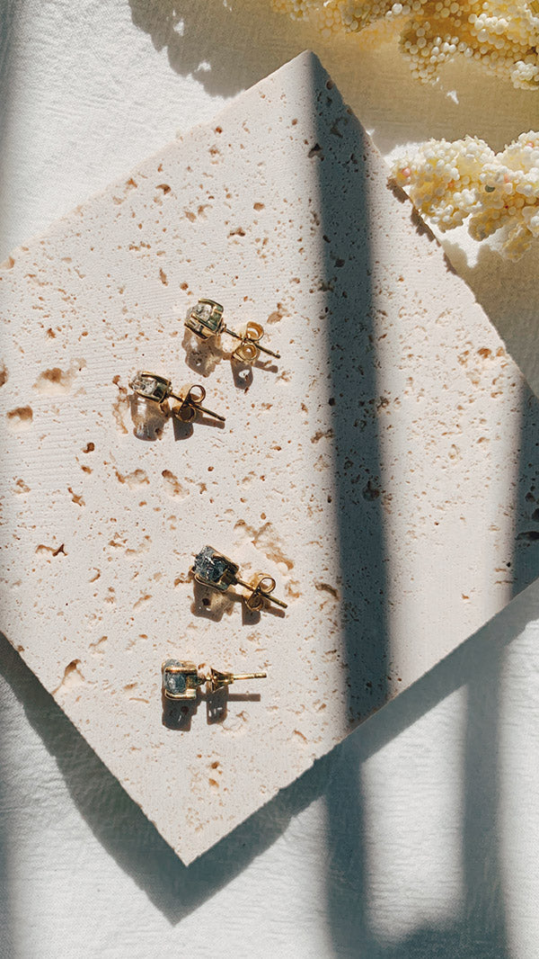 Mixture of raw diamond and Herkimer diamond studs under sunlight