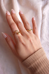 Model with white nails wearing elegant gold rings