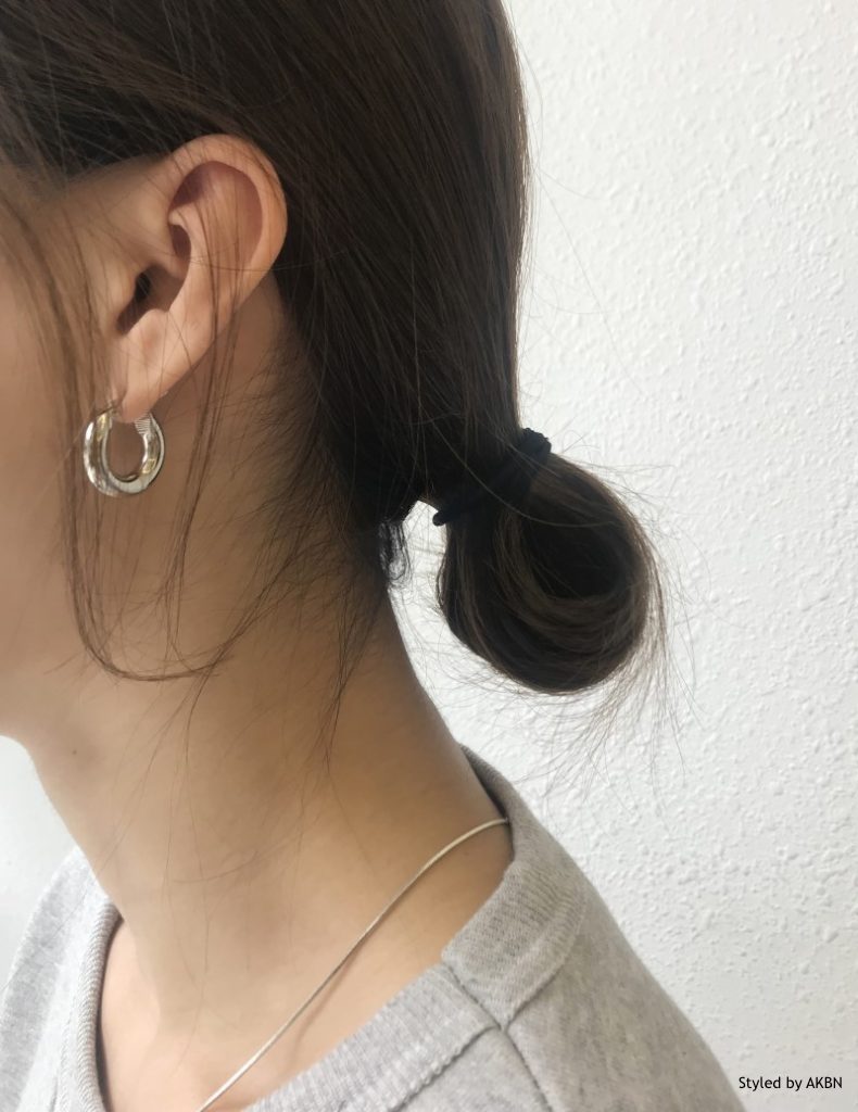 Side profile of a female with her hair tied up wearing SH & Co.'s Freja hoop earrings 