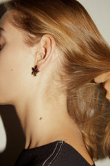 Western model holding her hair showing her starry trendy earrings