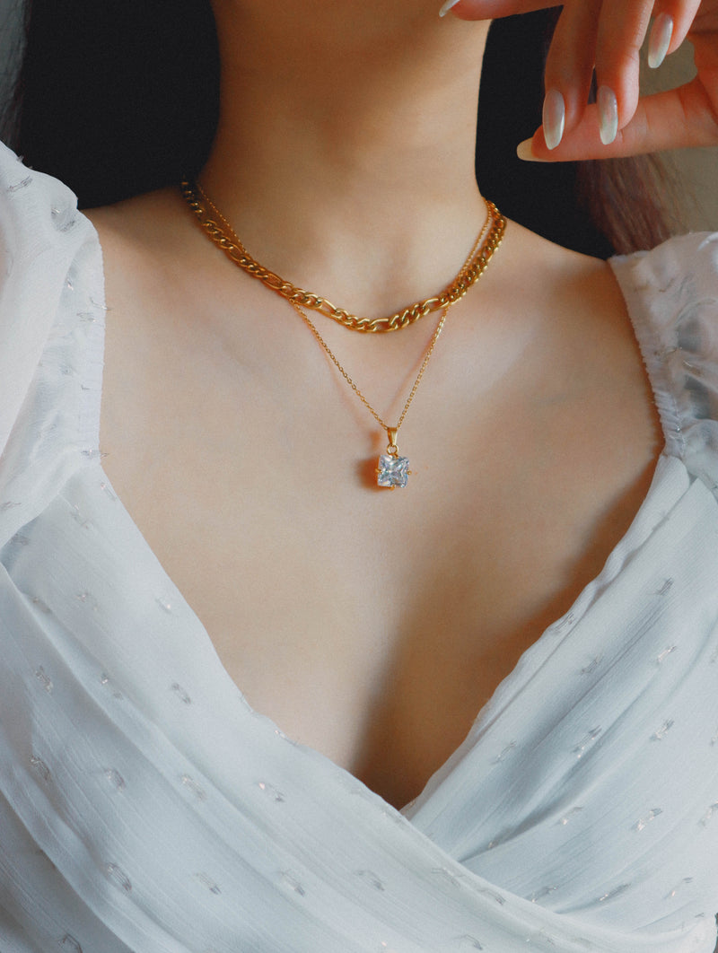Model layering necklace with figaro choker and white cz necklace
