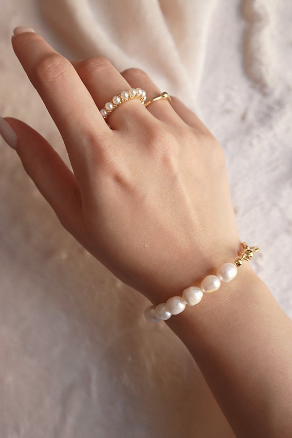 Model wearing elegant pearl jewelry on the right hand