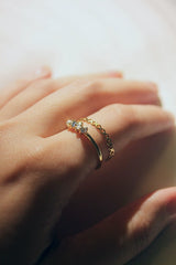 A gold with different types of gemstones on it stacked with another gold ring from SH & Co. Jewelry