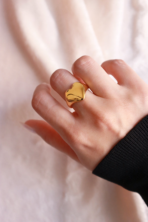 Model shows her hand wearing the heart shape gold ring to the camera