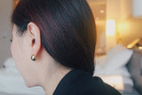 Jessica wears spherical gold earrings