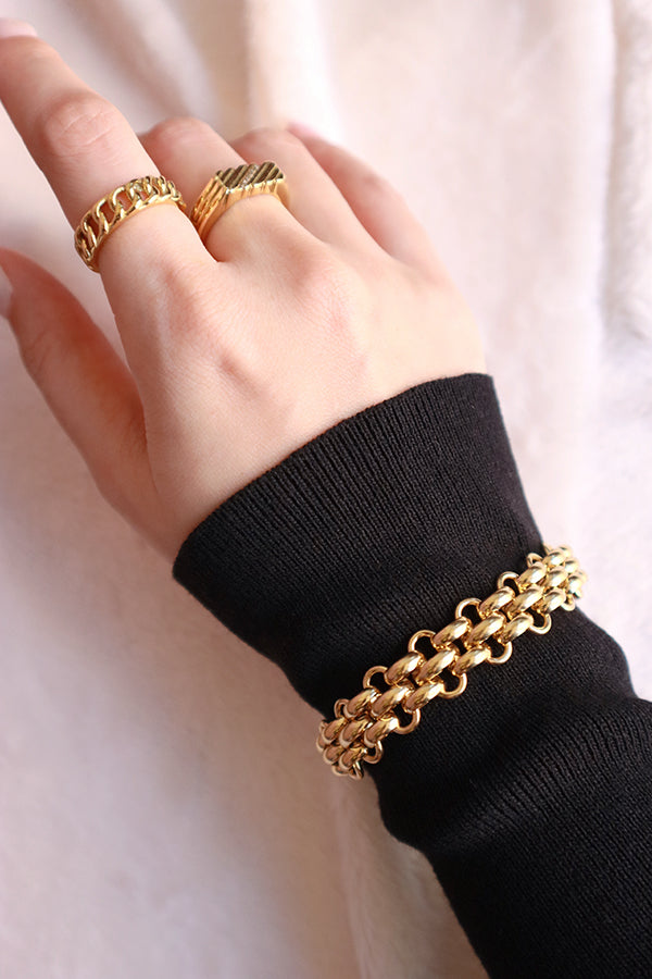Woman in black dress stacking style with gold rings and a gold bracelet