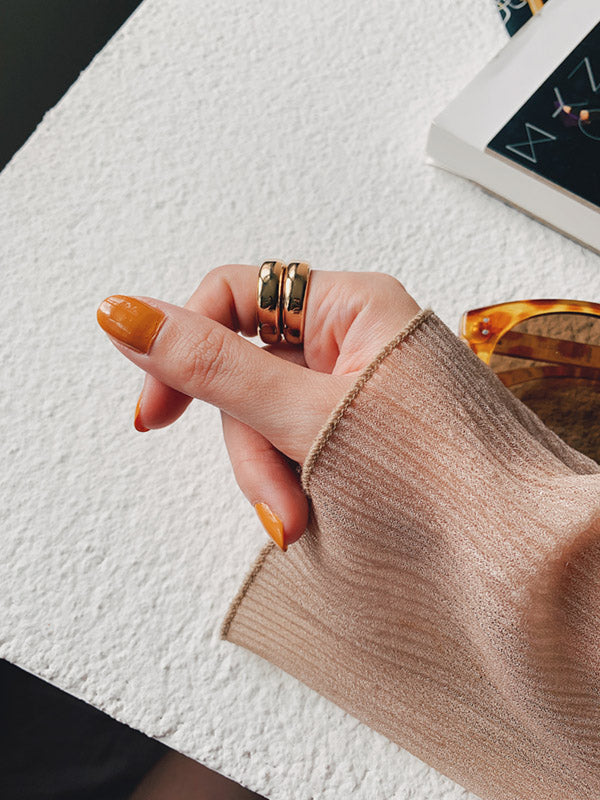 Woman posing stacked gold rings for instagram