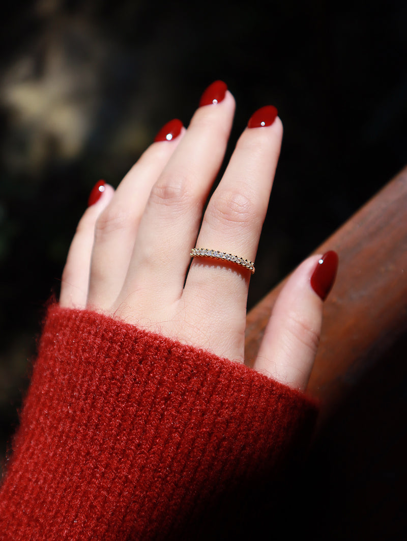 Woman in red sweater wearing a luxury gold ring with nails painted red