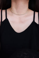 Woman in black dress wearing rhinestone choker