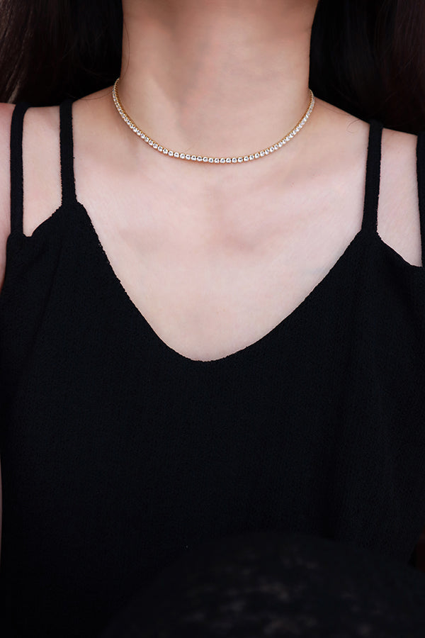 Woman in black dress wearing rhinestone choker