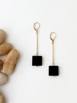 A pair of onyx earrings on a flat surface