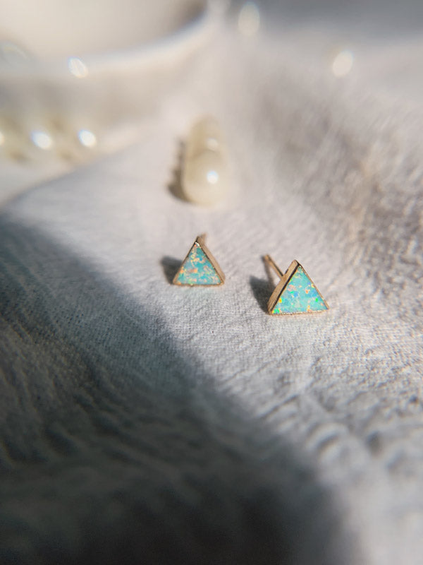 Small opal studs along with some pearls displayed on cloth handmade in USA 