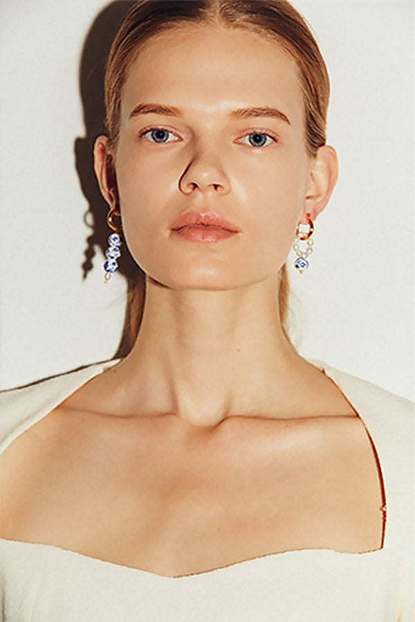 Caucasian model wearing blue and white porcelain earrings