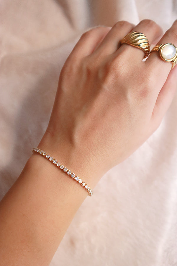 Model shows gold jewelry to the camera