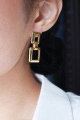 Business woman showing the minimalist gold earrings to camera