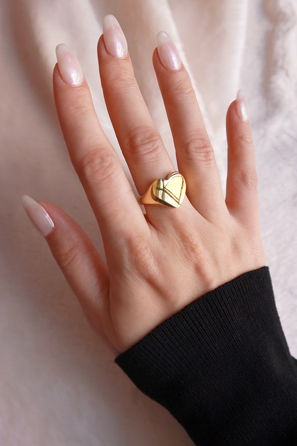 Woman wearing stainless steel gold ring on her right hand middle finger