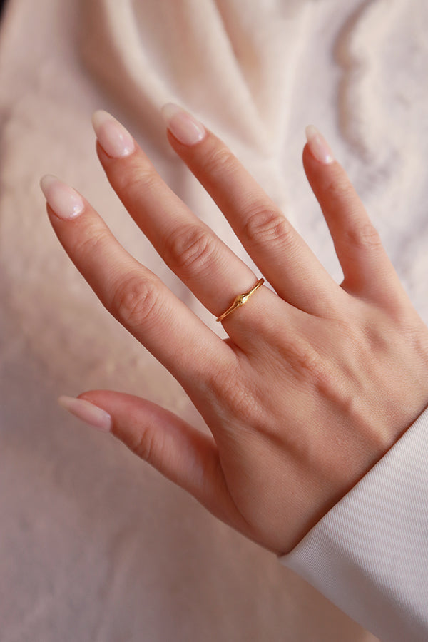 Model wearing a dainty gold ring that uses of stacking