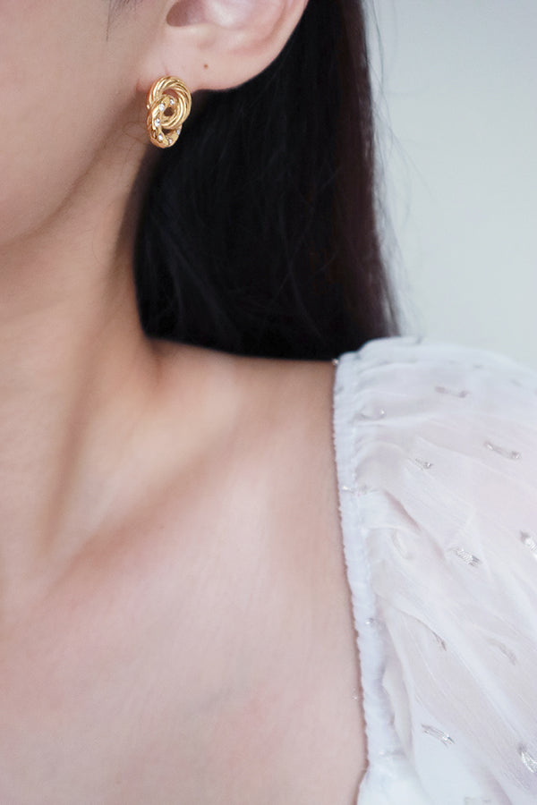 Woman in white wearing dainty cz earrings